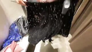 The hot girl tries on clothes in the fitting room and has sex there