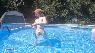 Redhead in red bikini underwater in the swimming pool, ignore the braids