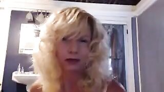 A mature woman caresses herself in the bathroom with a vibrator
