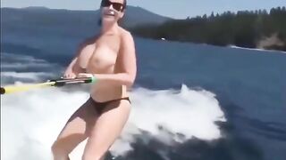 Girl in swimsuits skiing on the water surface without any support