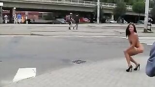 A stunning brunette with a graceful body poses in public for all to see