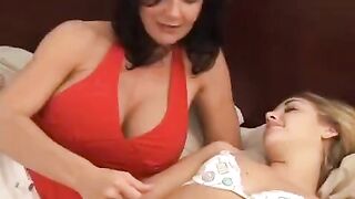 Two girls are having fun with a strapon in bed together