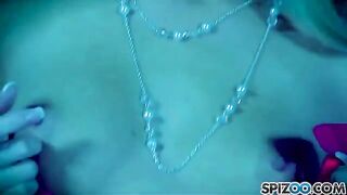 A blonde woman caresses her pussy with a dildo