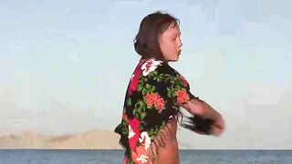 A member shows a girl the secrets of the nudist beach