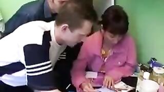 A Russian mom is having fun with three guys in the kitchen