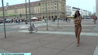 A hot chick is walking naked on the city streets and showing her ass