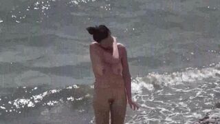 Nudist couple have fun on the beach in a naughty way