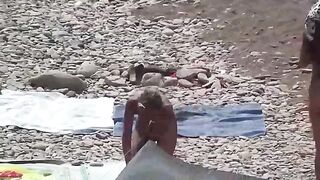 Nudist couple have fun on the beach in a naughty way