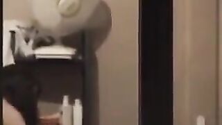 The guy looks at himself in the mirror completely naked
