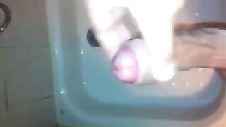 The kid masturbates his cock with his hand in the shower, trying not to cum