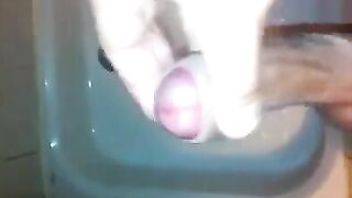 The kid masturbates his cock with his hand in the shower, trying not to cum
