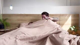 A man and woman are lying on the bed, so what are they doing there?